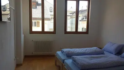 a living room with a couch and two windows at Argentieri Guesthouse in Bolzano