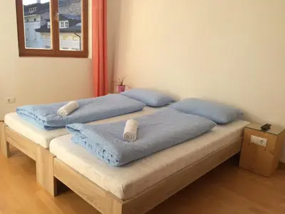 two beds in a room with blue pillows on them at Argentieri Guesthouse in Bolzano
