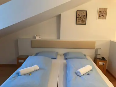 a bedroom with two beds with blue pillows at Argentieri Guesthouse in Bolzano