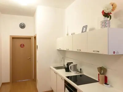 a kitchen with white cabinets and a sink at Argentieri Guesthouse in Bolzano