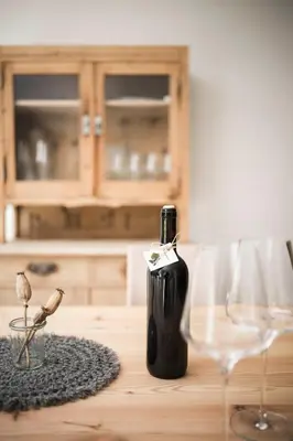 a bottle of wine sitting on a table next to a glass at Karerhof in Nova Levante