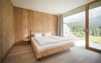 a bedroom with a bed and a large window at Karerhof in Nova Levante