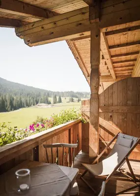 a wooden deck with a table and chairs on a porch at Karerhof in Nova Levante