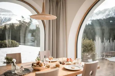 a dining room with a table and a large window at Karerhof in Nova Levante