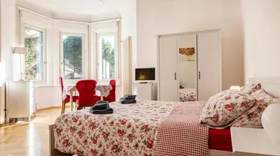 a bedroom with a bed and a table and chairs at Villa Anita Rooms in Bolzano