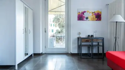 a living room with a red couch and a table at Villa Anita Rooms in Bolzano