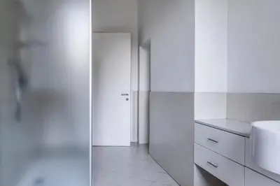 a white bathroom with a sink and a toilet at Villa Anita Rooms in Bolzano