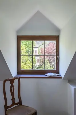 a chair in a room with a window at Villa Anita Rooms in Bolzano