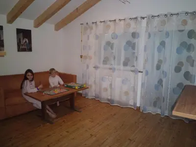 two children sitting at a table in a living room at Appartments Stoanegg in Parcines