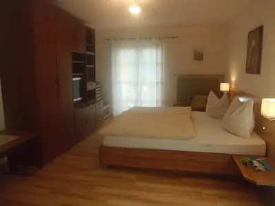 a bedroom with a large bed and a window at Appartments Stoanegg in Parcines