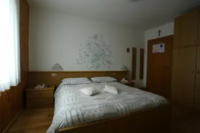 a bedroom with a bed with two pillows on it at Garni Miravalle in Moena