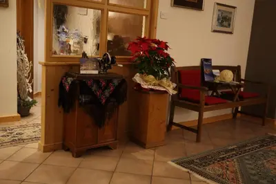 a living room with a table and a chair at Garni Miravalle in Moena