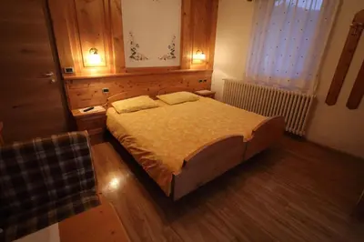 a bedroom with a large bed in a room at Garni Miravalle in Moena