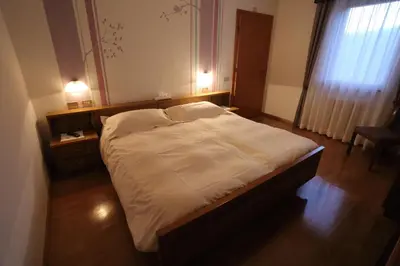 a bed in a room with two pillows on it at Garni Miravalle in Moena