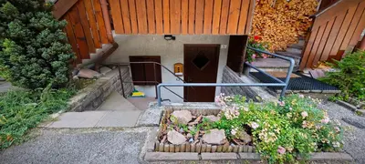 a stone wall in a room with a couch at Bilocale Nel Cuore Della Val Di Fiemme in Panchia