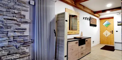 a living room with a large wall of logs at Bilocale Nel Cuore Della Val Di Fiemme in Panchia