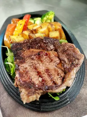 a plate of food with meat and vegetables on a table at Hotel Villa Argentina Ronzone in Ronzone