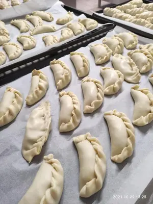 a bunch of uncooked dumplings on a baking sheet at Hotel Villa Argentina Ronzone in Ronzone