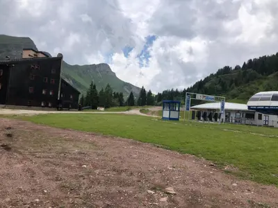 a field with a building and a soccer field at Paradise Dolomiti flat in Falcade
