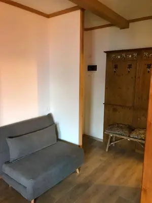 a living room with a couch and a cabinet at Paradise Dolomiti flat in Falcade