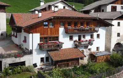 a large white building with balconies and red flowers at Stofflhof in Proves
