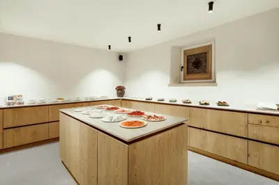 a large kitchen with a table with plates of food on it at ADLER Historic Guesthouse in Bressanone