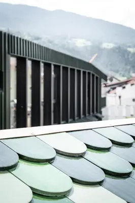 a row of green and white umbrellas on a roof at ADLER Historic Guesthouse in Bressanone