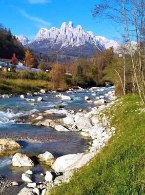a river with snow capped mountains in the background at Casa Lucia in Mezzano