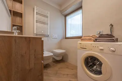 a washing machine in a bathroom with a toilet at Casa Lucia in Mezzano