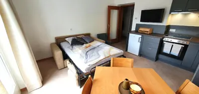 a room with a bed and a kitchen with a table at Zweizimmer-Wohnung mit Parkgarage in Naturno