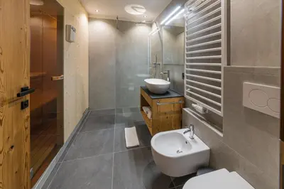 a bathroom with a white toilet and a sink at Residence Maximilian in Valdaora