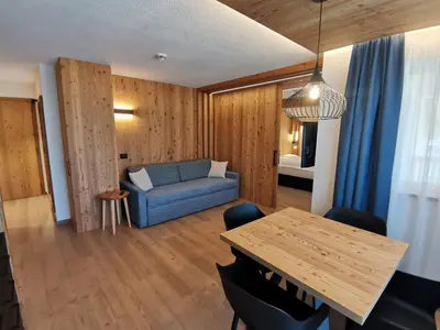 a living room with a blue couch and a table at Residence Maximilian in Valdaora