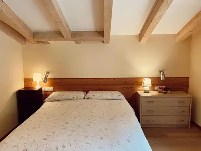a bedroom with a bed and two dressers and two lamps at Appartamento Romantico a Valles in Valles
