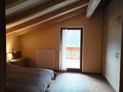 a bedroom with a bed and a large window at Appartamento Romantico a Valles in Valles