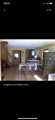 two pictures of a living room with a table and chairs at Appartamento Romantico a Valles in Valles