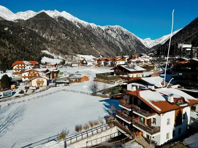 a small town with snow covered buildings and mountains at Appartamento Romantico a Valles in Valles
