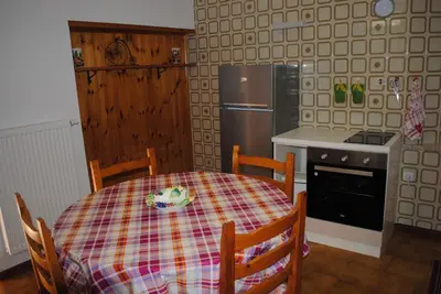 a kitchen with a table and a stove and a refrigerator at Casa Vacanza San Martino in Fondo