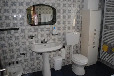 a bathroom with a sink and a toilet and a mirror at Casa Vacanza San Martino in Fondo