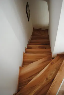 a staircase with wooden floors and a white wall at Casa Vacanza San Martino in Fondo