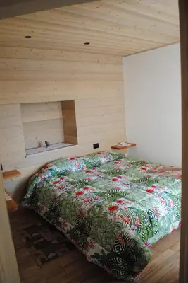 a bed in a room with a wooden wall at Casa Vacanza San Martino in Fondo