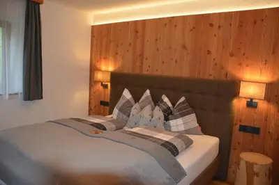 a bedroom with a large bed with two pillows at Pliegermoar - Adults Only in Vols am Schlern
