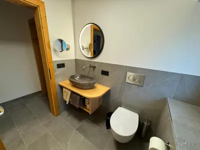 a bathroom with a sink and a toilet and a mirror at Pliegermoar - Adults Only in Vols am Schlern