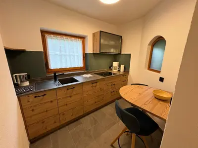 a kitchen with a sink and a wooden table at Pliegermoar - Adults Only in Vols am Schlern