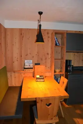 a kitchen with a wooden table with chairs and a lamp at Pliegermoar - Adults Only in Vols am Schlern