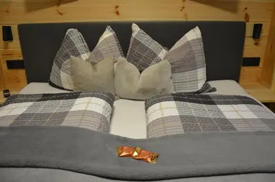 a bed with pillows and a bow tie on it at Pliegermoar - Adults Only in Vols am Schlern