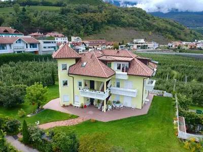 a large yellow house with a red roof at FeWo 4 am Martinshof in Eppan im Süden Südtirols in Eppan an der Weinstrasse ST. Pauls