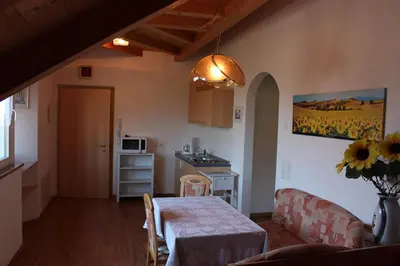 a kitchen and a dining room with a table and a kitchen at FeWo 4 am Martinshof in Eppan im Süden Südtirols in Eppan an der Weinstrasse ST. Pauls