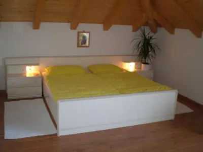 a bedroom with a bed with two lamps and a plant at FeWo 4 am Martinshof in Eppan im Süden Südtirols in Eppan an der Weinstrasse ST. Pauls