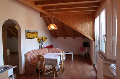 a living room with a table and a couch at FeWo 4 am Martinshof in Eppan im Süden Südtirols in Eppan an der Weinstrasse ST. Pauls