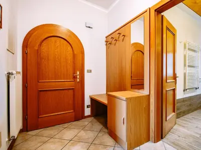 a hallway with a wooden door and a cabinet at Apartment Ardoney-1 by Interhome in Campitello